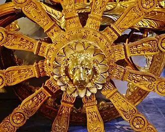 Tête de lion sur la roue arrière droite.