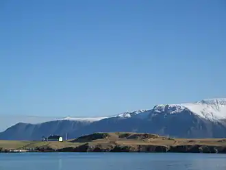 Viðey vu depuis Reykjavik avec l'Esja en arrière-plan.