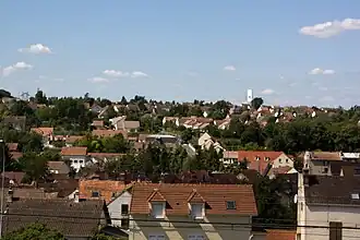 Vue d'un quartier d'une ville construit au flanc d'un coteau et alternant maisons individuelles et petits espaces verts.
