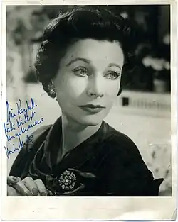 Portrait en noir et blanc d'une femme habillée de couleurs sombres. La photographie est dédicacée.