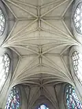 Plafond en briques claires, avec voûtes de style gothique et clés de voûte.