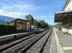 Vue d'ensemble des voies et des quais reliés par un passage pour les piétons.