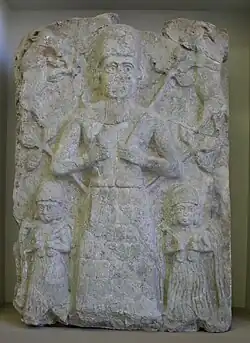 Bas-relief représentant un dieu, souvent identifié comme Assur, nourrissant deux caprins, avec deux déesses aux vases jaillissant à ses pieds. Assur, début du IIe millénaire av. J.-C.