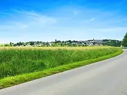 Vue générale du bourg côté sud depuis la nationale avant le lieu-dit de la Croix de l'Abbaye. Le centre du village est au sommet de la colline à 85 mètres d'altitude.