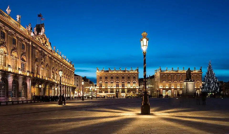 Candélabre et hôtel de ville (à gauche) de nuit.
