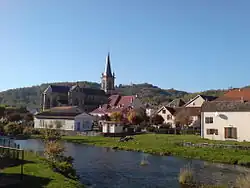 Groupe de bâtiments dont une église traversé par une rivière.