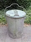Seau à ordure en métal galvanisé, avec couvercle monté sur charnière latérale; d'usage commun (Belgique, Pays-Bas) dans les années 1960.
