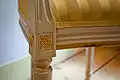 Assise rembourrée d'un fauteuil, détail du galon de passementerie dissimulant les clous.