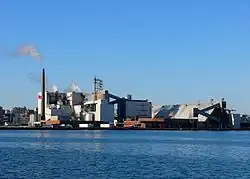 Une usine au bord de l'eau composé de plusieurs bâtiments.