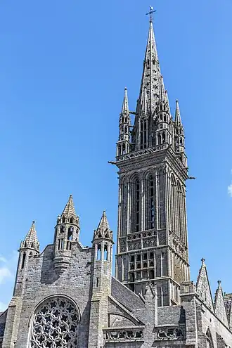 Chapelle Notre-Dame du Kreisker : tour couronnée d'un étage destiné aux cloches et d'une flèche octogonale flanquée sur ses pans de quatre hautes lucarnes et cantonné de quatre clochetons hexagones à trois étages ajourés par des baies superposées, dont les pinacles s'élèvent au-dessus de petits gables pleins.