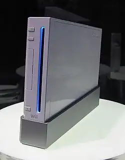 La console de jeu vidéo Wii posé à la verticale au milieu d'une petite table ronde.