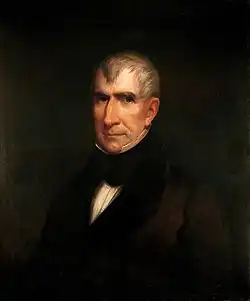 Harrison porte une veste noire avec col haut.