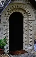 Double rangée de têtes sur l'archivolte et les piedroits à Windrush (Gloucestershire)