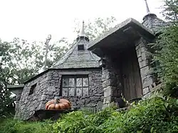 Une cabane en pierre vue en contre-plongée, semblant heptagonale, avec un toit pointu