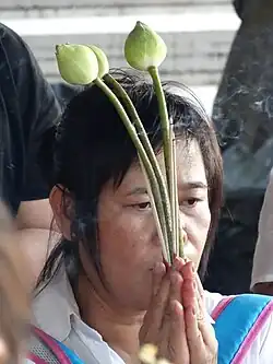 Femme thaïlandaise en prière au Wat Pho à Bangkok.