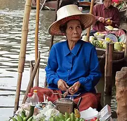 Vendeuse d'un marché flottant, le Damnoen Saduak Floating Market&nbsp;(en).