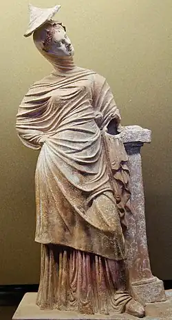 Jeune femme drapée appuyée contre un pilier, production de Tanagra, fin IIIe&nbsp;siècle&nbsp;av. J.-C. ou début IIe&nbsp;siècle&nbsp;av. J.-C. Musée du Louvre.