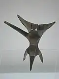 L'évolution des matières et des décors sur une même forme, le tripode jue, au cours de l'âge du Bronze ancien ; de gauche à droite : exemplaires en céramique et en bronze de la période d'Erlitou sans décor, et exemplaire en bronze de la période d'Erligang décoré d'un taotie.