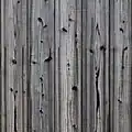 Façade ancienne en yakisugi : le bois mis à nu sous le charbon a grisé, les nœuds sont restés brûlés.