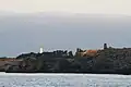 Au loin le grand phare de l'île d'Yeu (de couleur blanche) et, au centre sur la côte rocheuse, le Vieux Château.