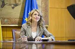 Une femme assise à un bureau.