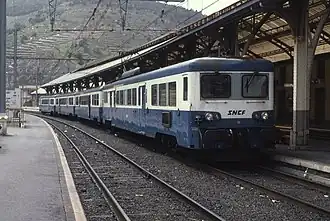 Photo couleur d'une automotrice en livrée bleu, blanc et gris à quai en gare