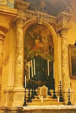 Peinture figurant un homme en soutane regardant le ciel où se trouvent anges et chérubins.